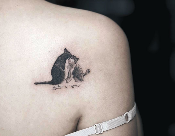 tatuaje muy simpático representando dos gatos, ideas de tatuajes en el hombro mujer, tendencias en los diseños 2018