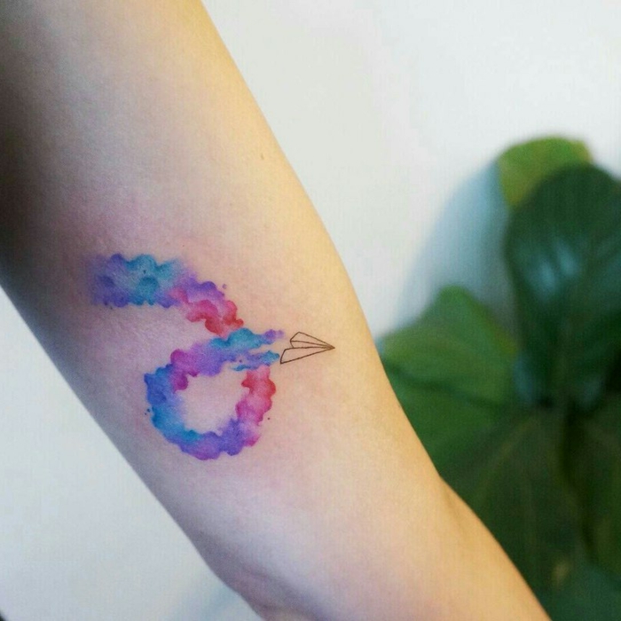 tatuajes bonitos con acuarela, espirala con manchas de color y dibujo de avión de papel en negro 