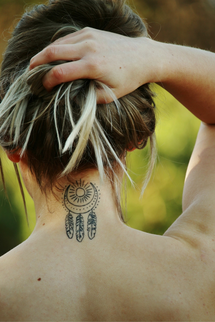 tatuajes de mujer con significado, bonito tatuaje en la nuca con dibujo de atrpasueños y sol 