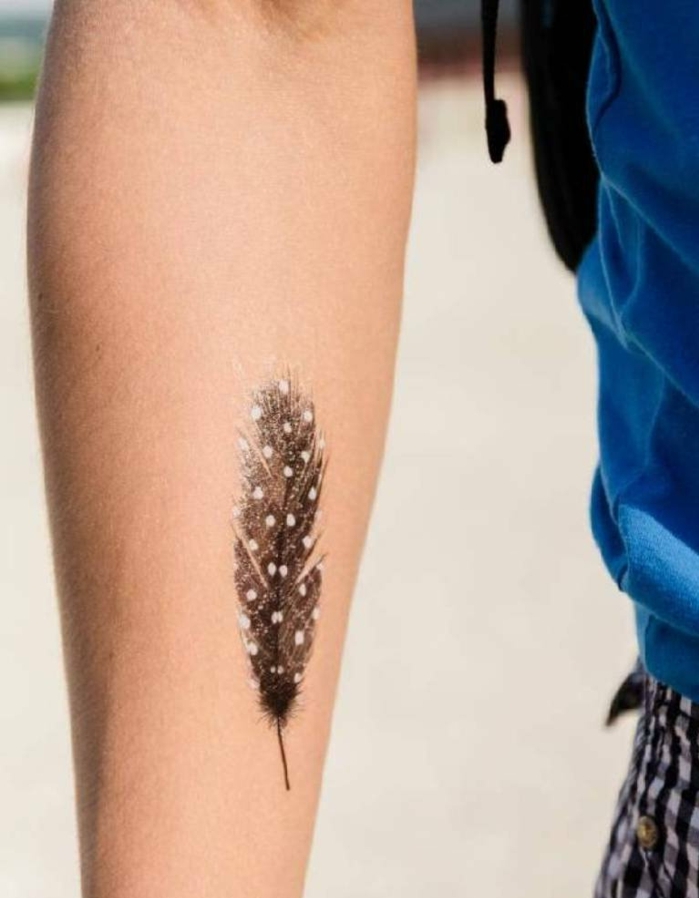 tatuajes de plumas para hombres, precioso tatuaje en el brazo de pluma negra con puntos blancos
