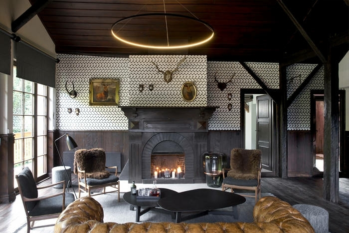 precioso salon decorado en colores oscuros, decoracion rustica y muebles de epoca, sofá tapizado en piel en marrón