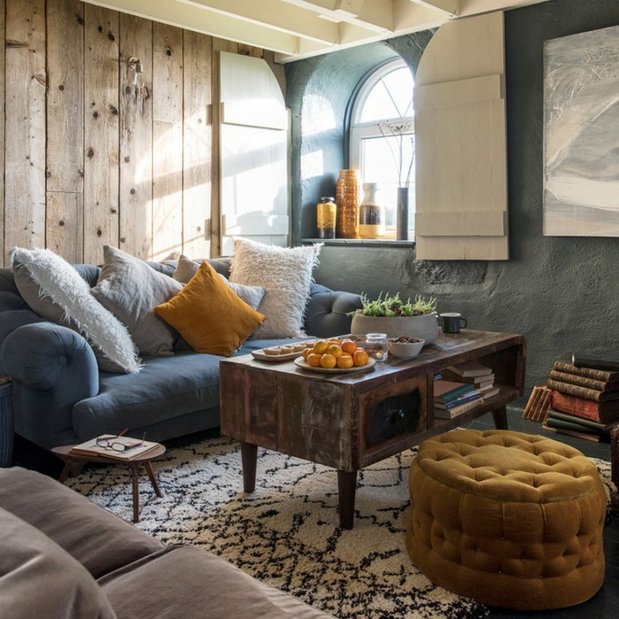 diseño de salones rusticos, decoracion bonita en tonos claros, azul, blanco, gris y mostaza, paredes de madera y alfombra ornamentada