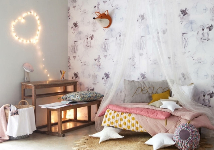 preciosas ideas para decorar habitaciones infantiles baratas, espacio pequeño decorado en colores claros, pared con papel pintado y cojines en forma de estrellas 
