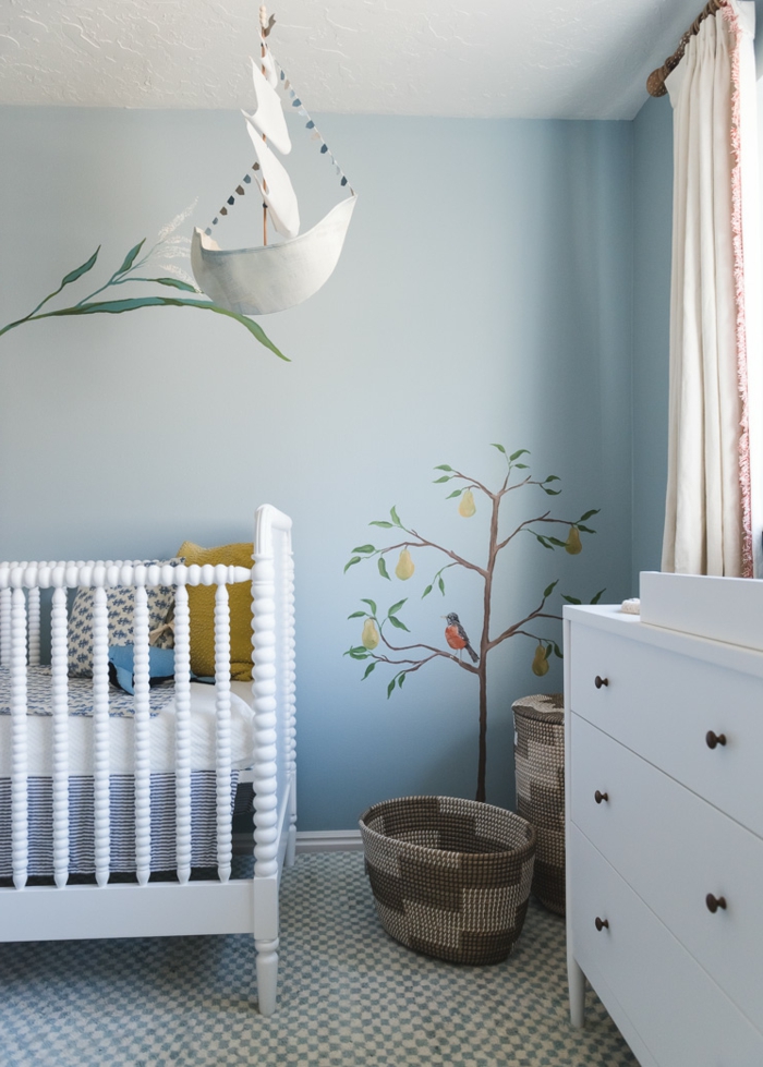precioso ejemplo de cuartos de niñas modernas, cama de bebe en blanco, paredes en azul con dibujos 