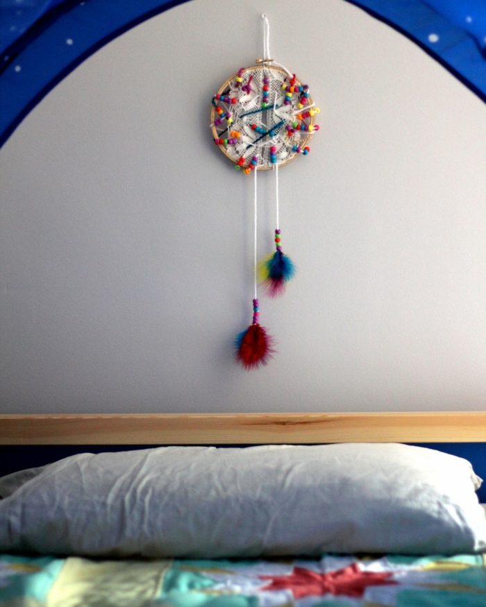 pequeños atrapasueños colorido con pompones colgado sobre la cama, manualidades decoracion originales 