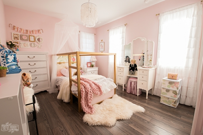 grande habitación decorada en rosado con elementos y muebles en blanco y suelo de madera, ideas de cuartos de niñas modernos