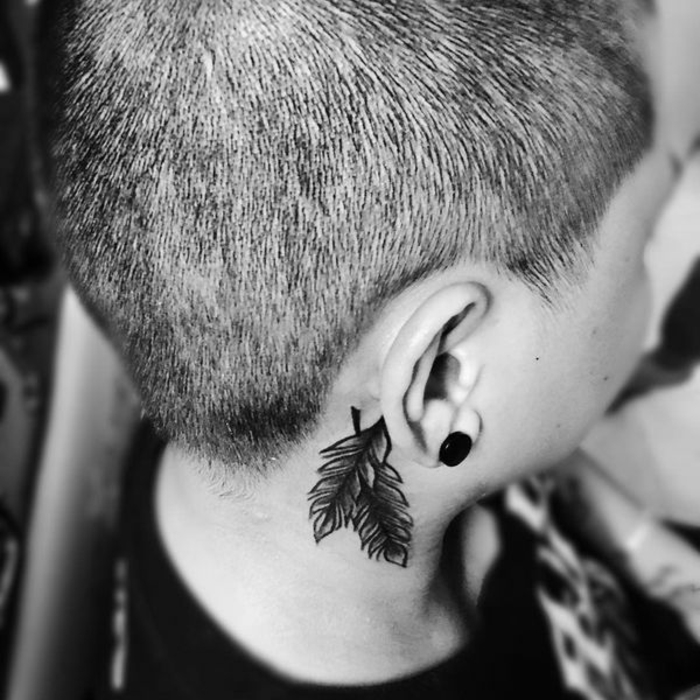 propuestas originales de tatuajes para hombre y mujeres, plumas cruzadas con tinte negro detrás de la oreja, ideas plumas indias