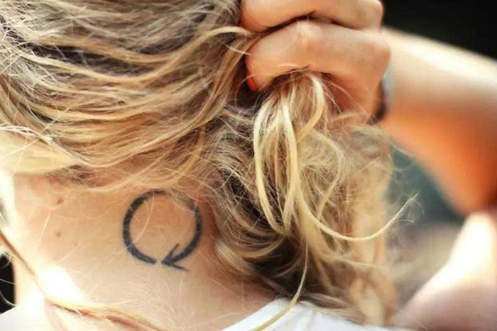 diseños de tatuajes medio circulo con flecha tatuado en la nuca, tendencias tatuajes simbolicos mujer 