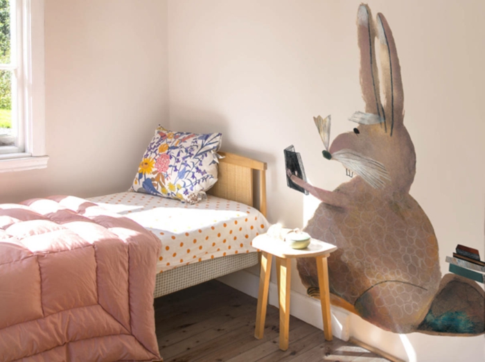 decoracion dormitorios de niñas, paredes en color pastel, cama individual de madera y vinilo de pared con dibujo de conejo 