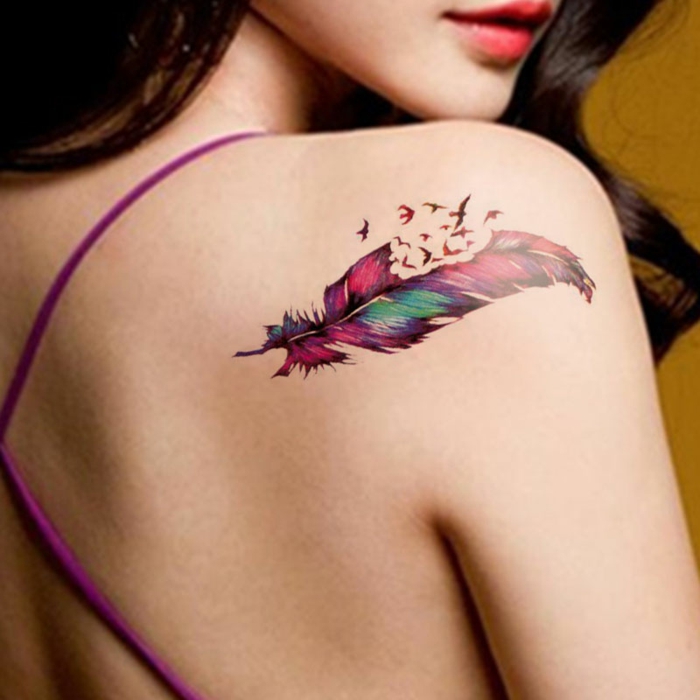 precioso diseño de tatuaje en el hombro con pìntura acuarela, plumas indias descomponiéndose con aves en pleno vuelo 