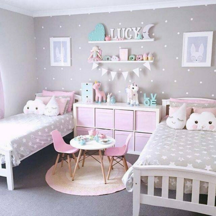 habitacion niñas decorada en gris y rosado, dos camas individuales y decoracion de cojines en forma de estrellas 