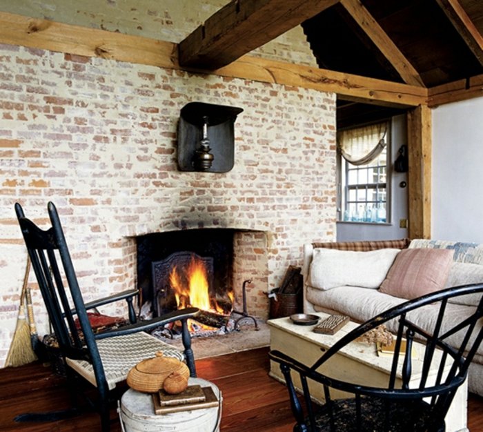 salon acogedor con paredes de ladrillo y vigas de madera en el techo, decoracion rustica con chimenea de leña