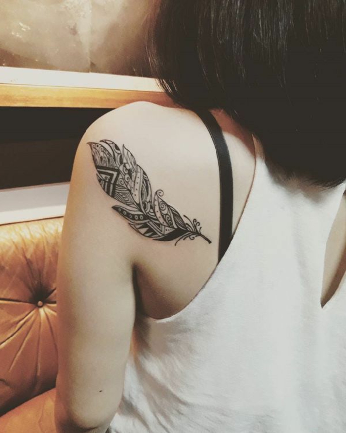 ejemplosd e tatuajes en el brazo y la espalda, pluma en negro ornamentada tatuada en la espalda, ideas tatuajes simbolicos mujer