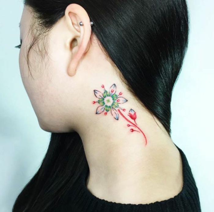 tatuajes simbolicos para mujeres en la nuca y detras de la oreja, bonita flor en colores en el cuello 