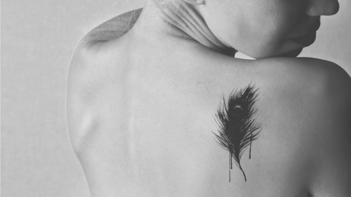 hermosa ideas de tatuajes pequeños para mujer, bonita pluma con tinte negro en la espalda, tendencias tatuajes 2018 