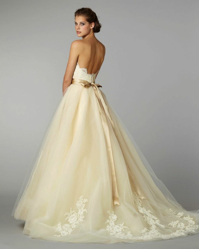 precioso vestido en color marfil con falda amplia adornada de apliques de flores, cinta en dorado y espalda descubierta
