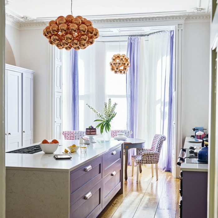 ideas de decoración moderna cocinas con isla, espacio decorado en tonos claros con acentos en lila y lamparas en cobrizo 