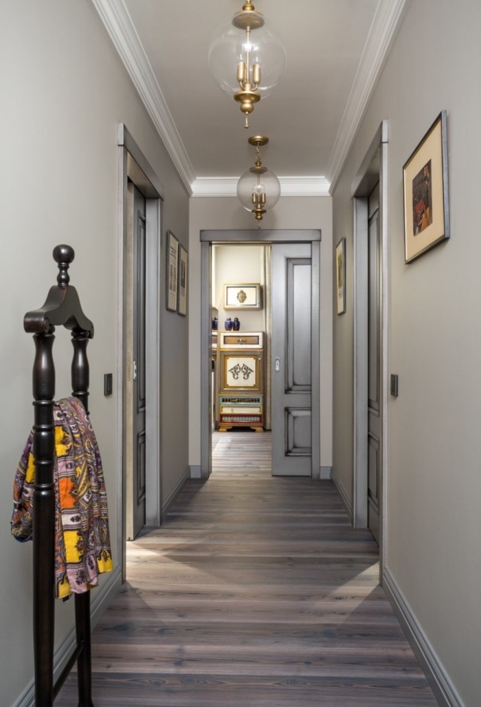 ideas originales sobre cómo decorar un pasillo largo, paredes en beige y gris, suelo de parquet y detalles decorativos 