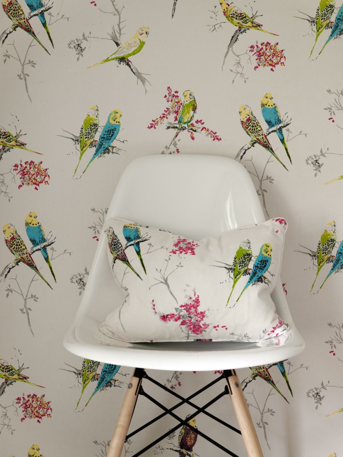 papel pintado salon ideas originales, pared decorada con papel pintado salon con dibujos de aves en colores y cojín decorativo con el mismo estampado 