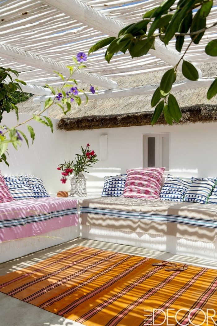 patios decorados n estilo africano, precioso diseño con cojines decorativos en blanco, rojo y azul 