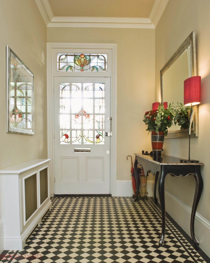 ejemplo de decorar pasillos estrechos, suelo con azulejos en negro y beige, muebles vintage y grande espejo con marco dorado 