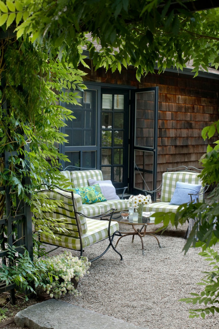 tendencias en la decoracion de exteriores, muebles de diseño con colchonetas en verde y blanco y suelo pavimentado 