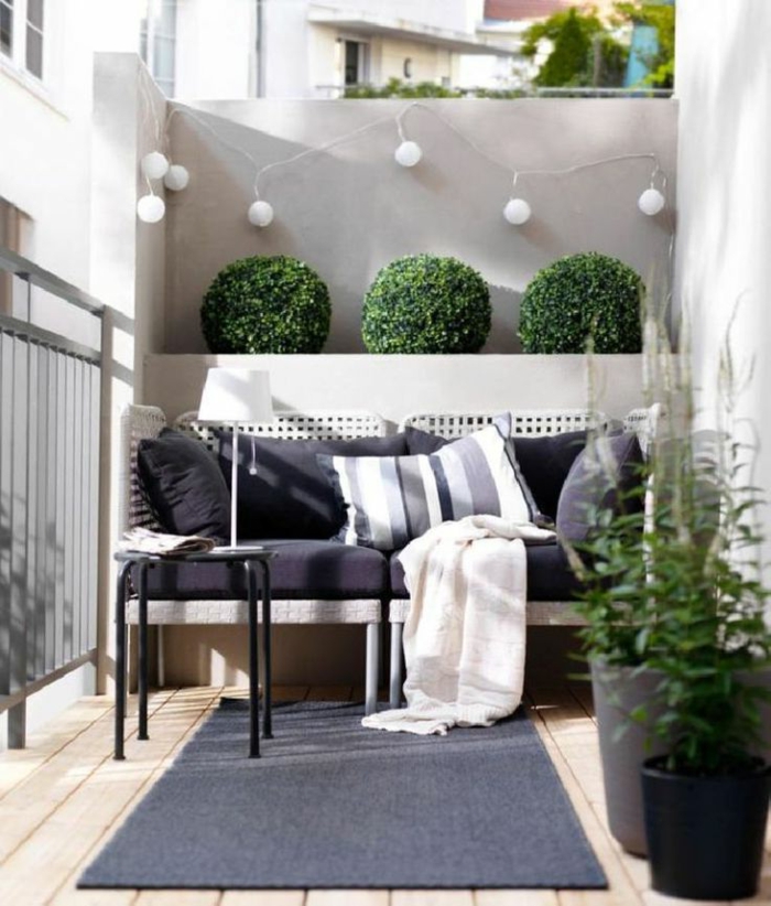 decoracion de terrazas con guirnaldas de luces y arbustos ornamentales, mueble de diseño en beige y negro 
