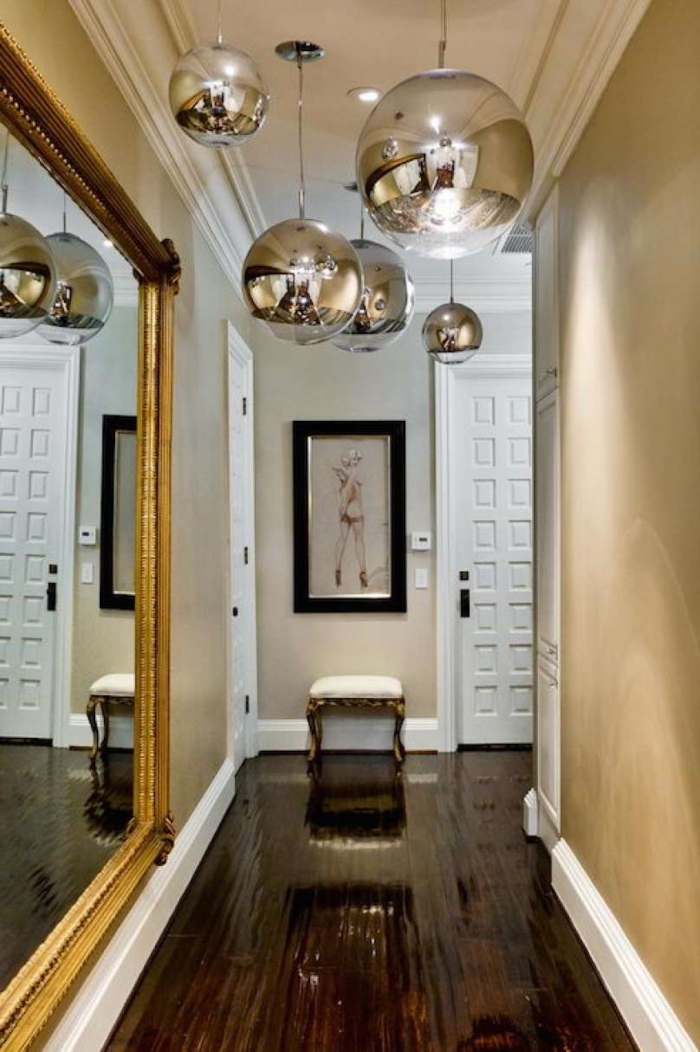 consejos e ideas sobre cómo decorar un pasillo largo y estrecho, grande espejo con marco dorado y lámparas en plateado 