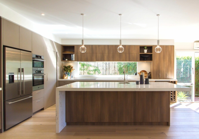 bonita decoracion cocinas moderna con lámpras originales de diseño, isla con barra en blanco 