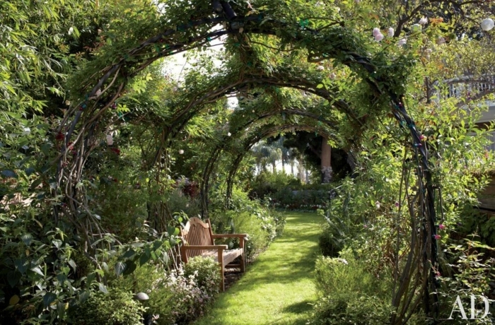 como decorar un jardin pequeño de maravilla, arcos de árboles, sendero con césped y banco de madera 