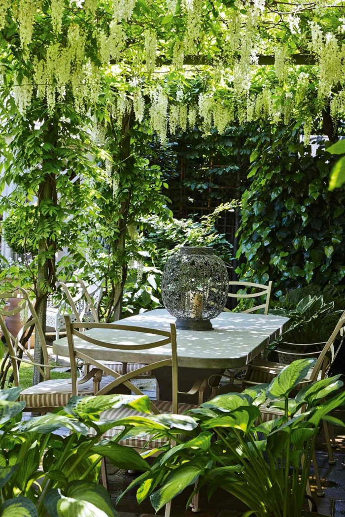 patio de encanto con mucha vegetación, cómo decorar un jardín pequeño, últimas tendencias en decoración de exteriores 