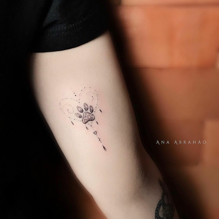 tatuajes simbólicos en el brazo, precioso diseño con pata de animal corazon, diseño original tatuaje