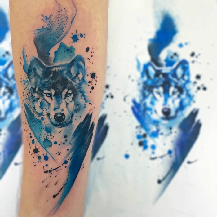 tatuajes simbolicos con lobos, símbolo de fuerza y fuerte carácter, tatuaje con pintura acrílica en azul, significado de tatuajes para mujeres 