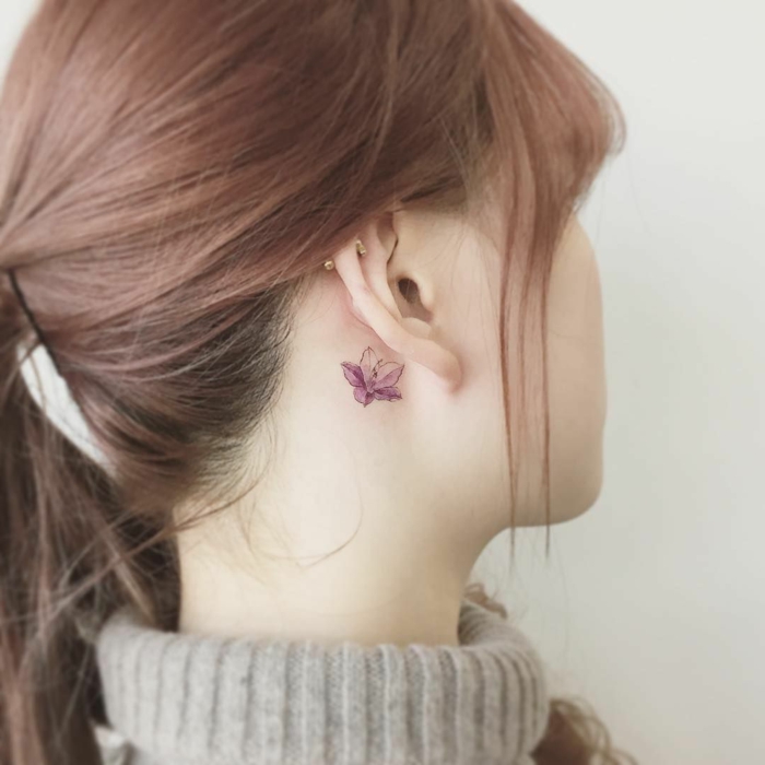 tattoos pequeños detrás de la oreja, tatuaje delicado y bonito de una flor en color lila, ideas de tattoos femeninos 