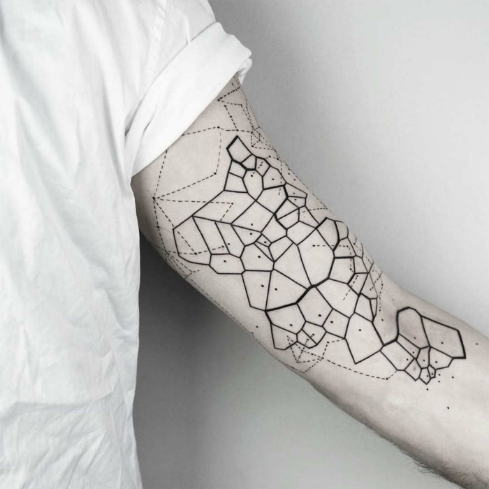brazo tatuado de manera encantadora, mapa en estilo geométrico, últimas tendencias en los tatuajes geometricos