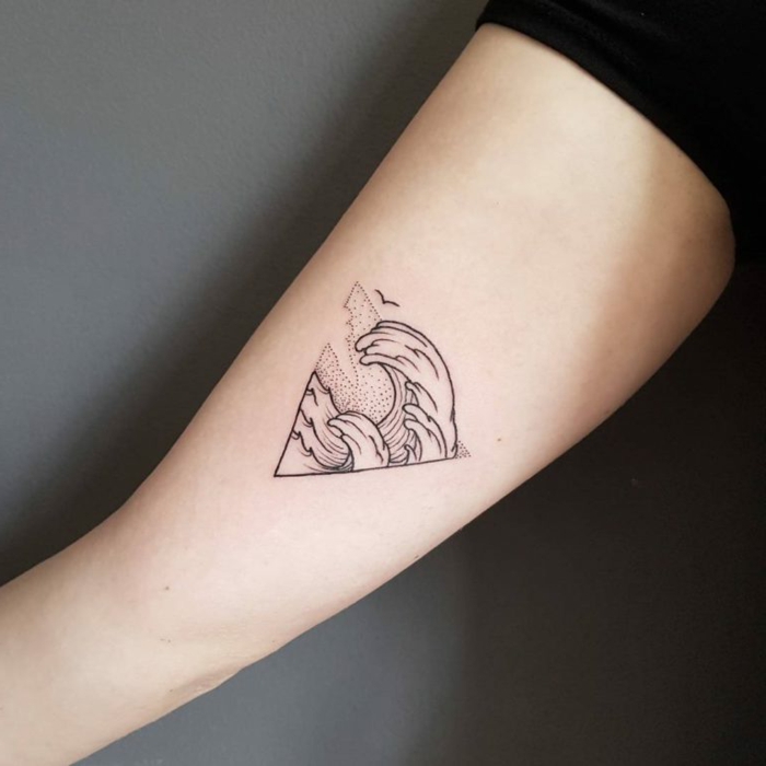 tatuajes de triangulos con significado, tatuaje minimaslita en el brazo, triángulo con olas del mar 