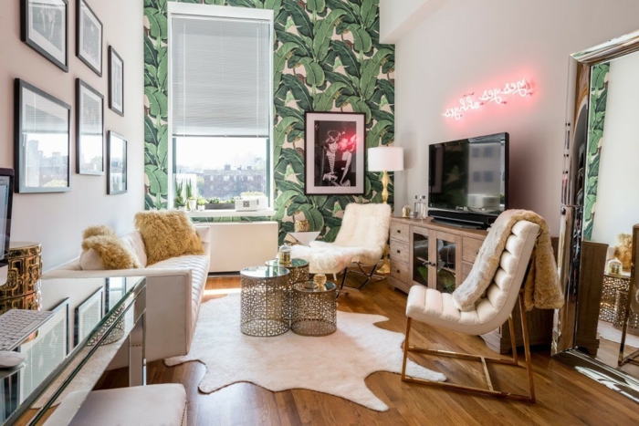 decoracion salon pequeño, salon moderno con tapete de hojas verdes en una pared y sillones con sofa de cuero