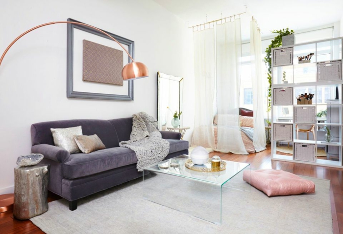 decoración salon moderno con sofa de terciopelo en color lila y cojin en rosa pastel y mesa de vidrio