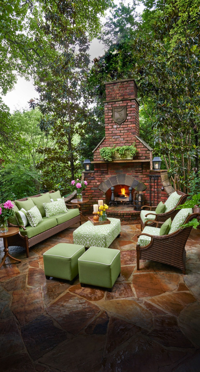 diseño jardines, decoración con sofá y sillones con almahodas en verde y chimenea con fuego ardiendo