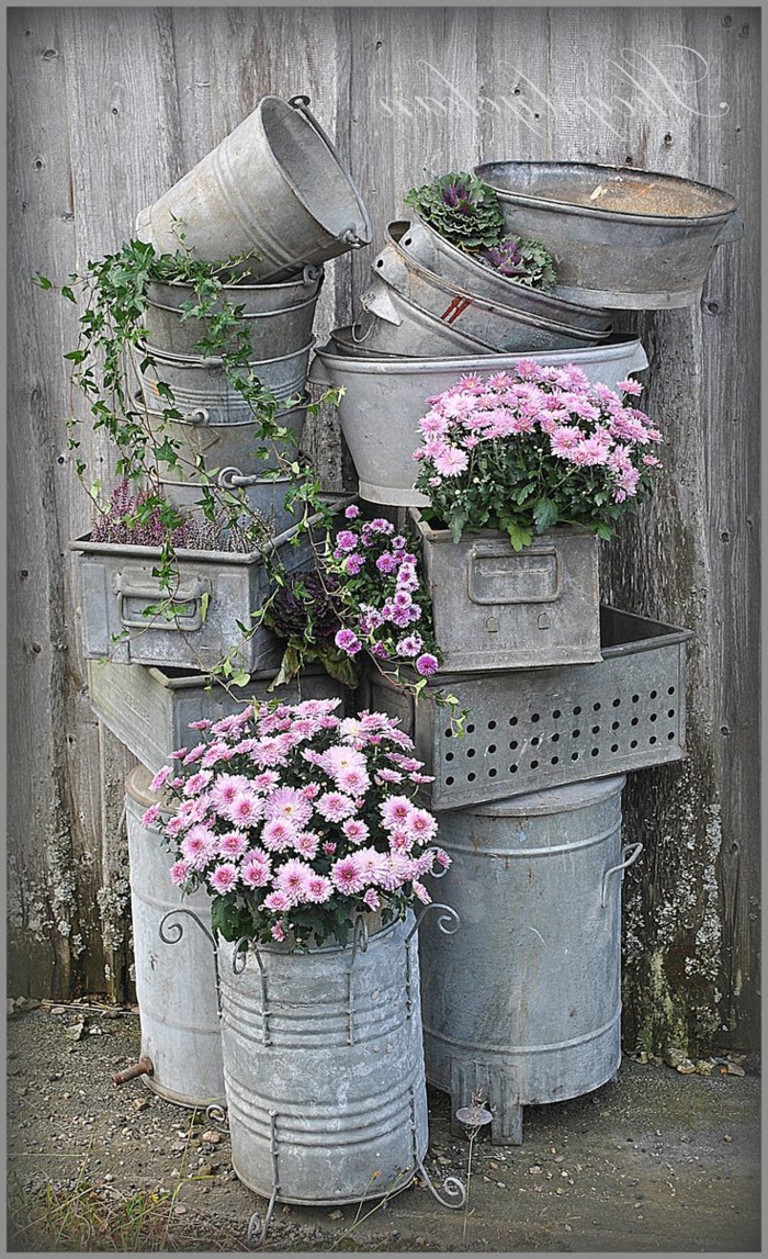jardines modernos, decoracion con muchos cubos viejos, metálicos decorados con flores rosas 