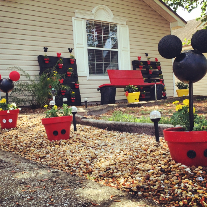 jardines modernos, el jardín de Disney con macetas del cuerpo de Mickey mouse y su cabeza en rojo y negro
