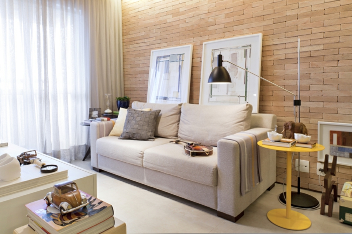 decoracion de pisos pequeños, sofa de doble asiento en color crema y mesa pequeña en amarillo