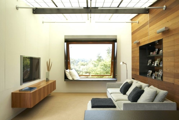 decoracion de pisos pequeños, sofa en gris claro con cojines en negro y con televisor en la pared