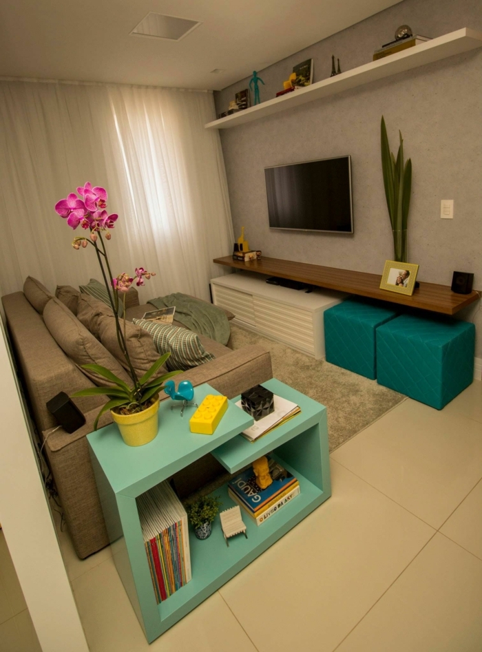 decoracion de pisos pequeños, salon con sofa en marron, estanteria en azul claro con orquidea rosa
