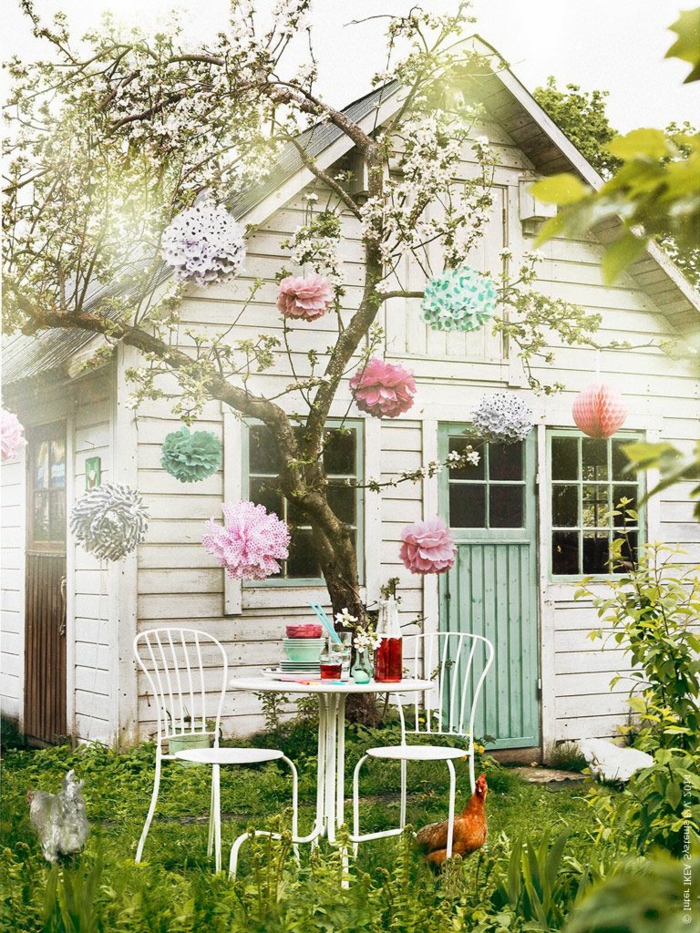 ideas para jardines, casa rústica en blanco con puerta en azul con árbol decorado con flores de papel