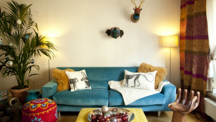 sofas pequeños , sofa de terciopelo en azul con cojines blancos con monos y otomana tipo etnico
