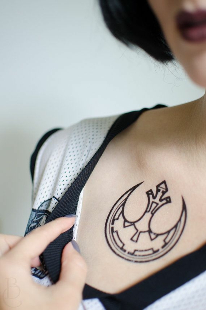 tattoos pequeños con simbolismo mujer, tatuaje con tinte negro en el escote, tatuajes originales mujer 