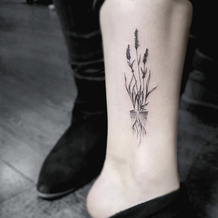 tatuajes con flores, maceta con flores con raíces, tatuajes mujer simbolo de fuerza, diseño muy original 
