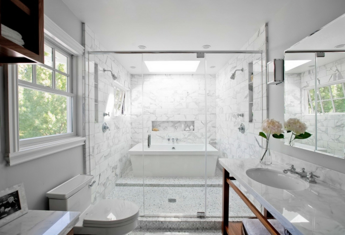 cuarto de baño grande decorado en blanco, decoracion cuartos de baño suelo de mármol, espejo y decoración de flores 