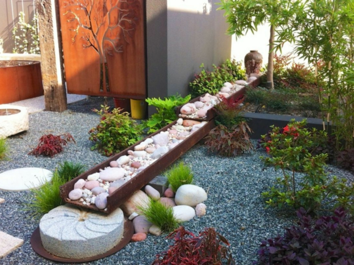 ideas para decorar jardines en estilo zen, suelo con gravilla en color oscuro, decoración de piedras y canto rodado 